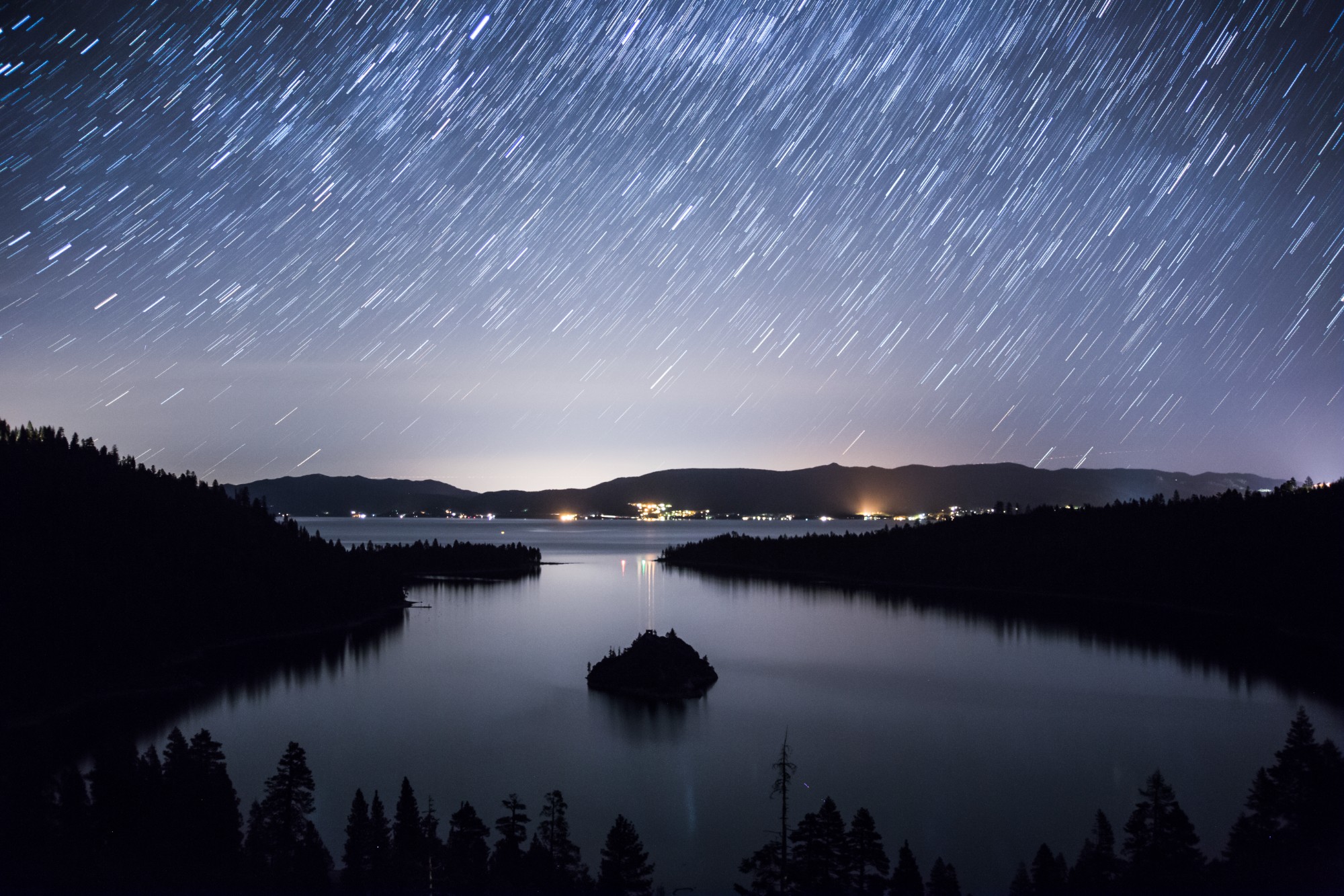 Long-exposure star trails arcing over Emerald Bay at Lake Tahoe
