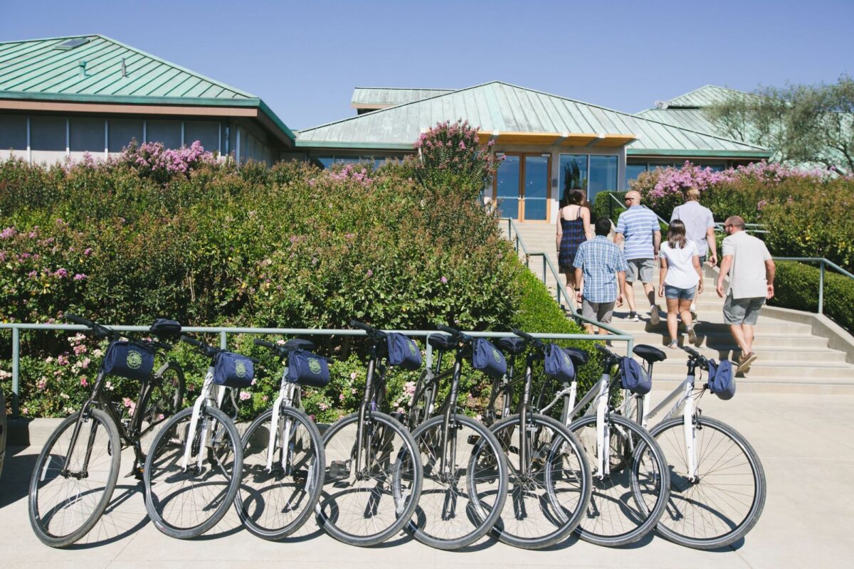 Bicycles parked outside Laird Family Estate as visitors walk toward the winery entrance.